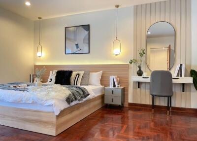 Spacious and modern bedroom with wooden floors and a cozy bed