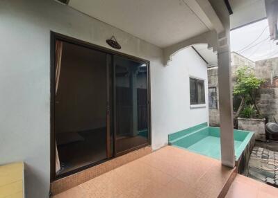 Covered patio area with sliding door leading to the house