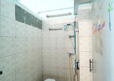 Simple bathroom with tiled walls and a toilet.