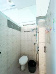 Simple bathroom with tiled walls and a toilet.