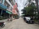 Street view with buildings and parked vehicles.