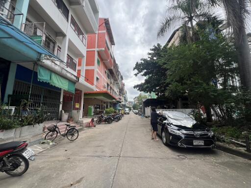 Street view with buildings and parked vehicles.