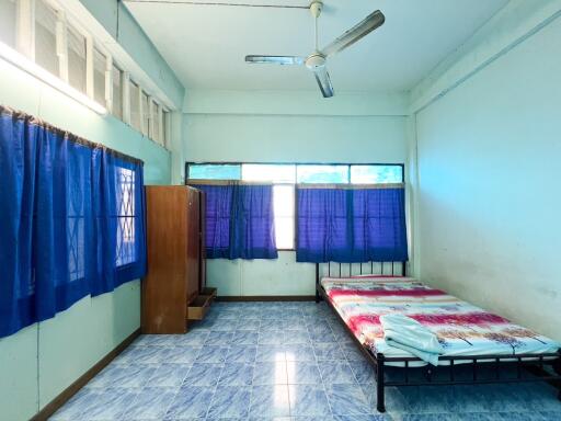 Simple bedroom with blue curtains and a single bed