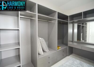 Spacious walk-in closet with built-in shelves and a vanity area