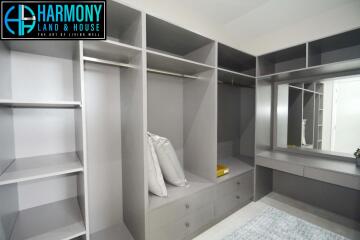 Spacious walk-in closet with built-in shelves and a vanity area