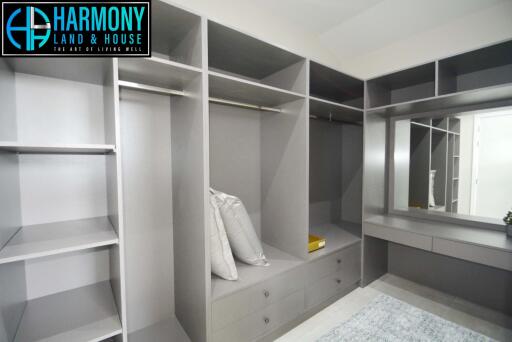 Spacious walk-in closet with built-in shelves and a vanity area