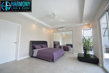 Modern bedroom with bed, mirrored wardrobe, and ceiling fan