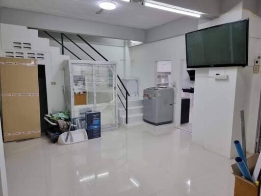 Clean living area with staircase and appliances