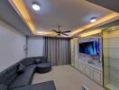 Modern living room with recessed lighting, sectional sofa, TV, and glass shelves