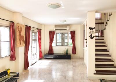 Bright and spacious living room with large windows and staircase