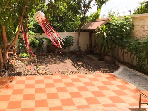 Well-maintained backyard with tiled floor and garden