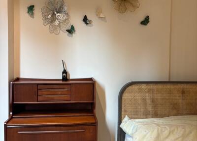 Bedroom with wooden dresser and bed