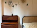 Bedroom with wooden dresser and bed