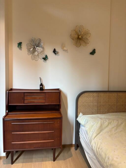 Bedroom with wooden dresser and bed