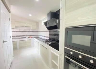 Modern kitchen with white cabinetry and built-in appliances