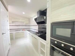 Modern kitchen with white cabinetry and built-in appliances