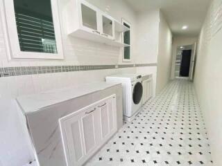 Spacious laundry room with cabinets and washing machine