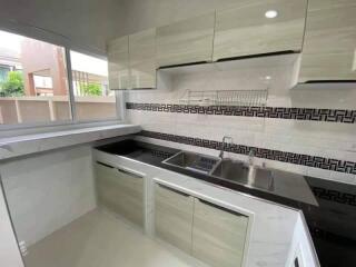 Modern kitchen with cabinets and large window