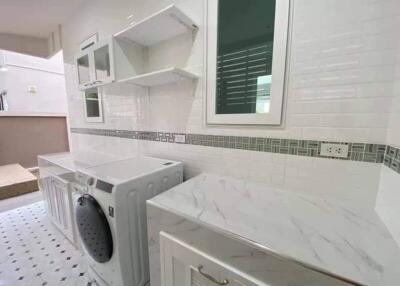 Modern laundry room with washing machine and storage cabinets