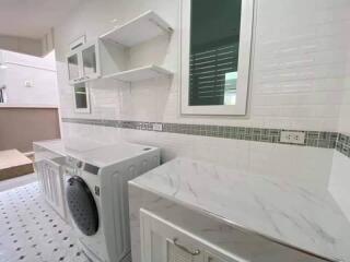 Modern laundry room with washing machine and storage cabinets