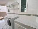 Modern laundry room with washing machine and storage cabinets