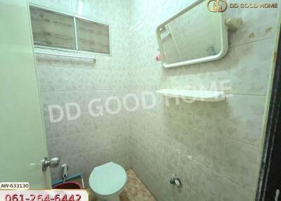 Bathroom with basic amenities and tiled walls