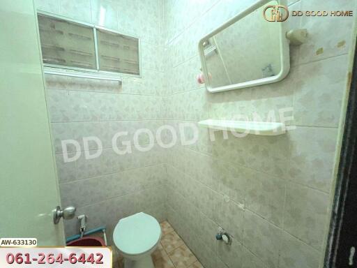 Bathroom with basic amenities and tiled walls