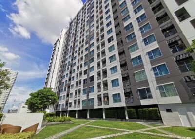 High-rise residential building exterior with lawn area