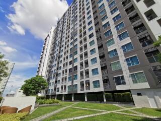 High-rise residential building exterior with lawn area