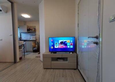 Living area with TV and adjacent kitchen