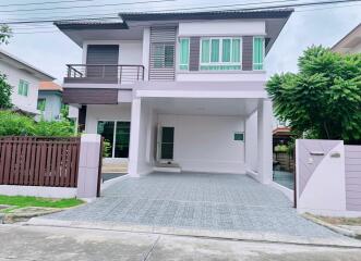 Modern two-story house with a driveway and a balcony