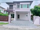 Modern two-story house with a driveway and a balcony