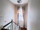 A modern staircase with natural lighting from a window