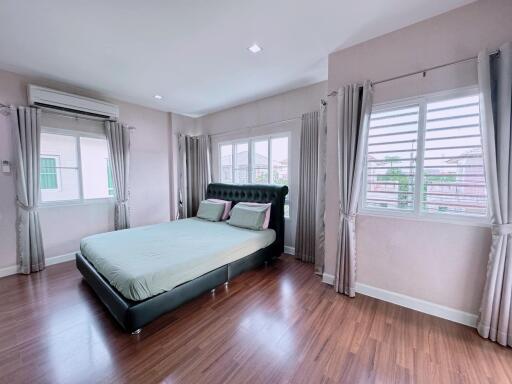 Spacious bedroom with large windows and hardwood floors