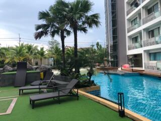 Outdoor swimming pool area with lounge chairs and greenery