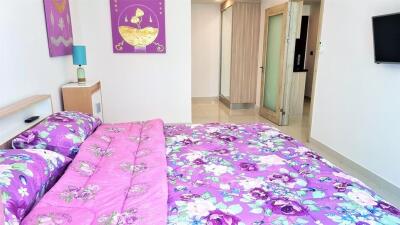 well-lit bedroom with colorful bedding