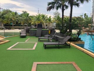 Outdoor pool area with lounge chairs and palm trees