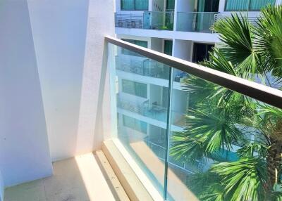 Balcony with glass railing overlooking neighboring buildings