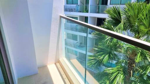 Balcony with glass railing overlooking neighboring buildings