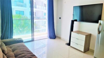 Modern living room with a sofa, flat-screen TV, and balcony view