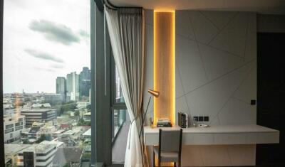 Bedroom with desk and window view of urban landscape