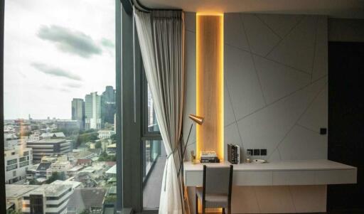 Bedroom with desk and window view of urban landscape