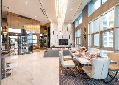 Luxurious open-plan living and dining area with modern decor, large windows, and elegant furnishings