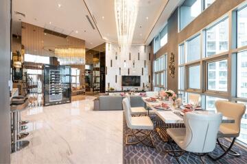 Luxurious open-plan living and dining area with modern decor, large windows, and elegant furnishings