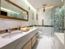 Modern bathroom with marble countertops, large mirror, and glass-enclosed shower