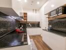 Modern kitchen with black tiled backsplash and white cabinetry