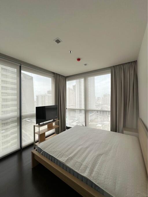 Modern bedroom with large windows and city view