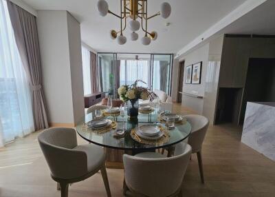 Modern dining area with a round glass table set for a meal