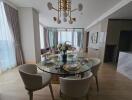 Modern dining area with a round glass table set for a meal