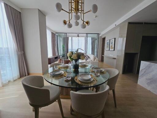 Modern dining area with a round glass table set for a meal